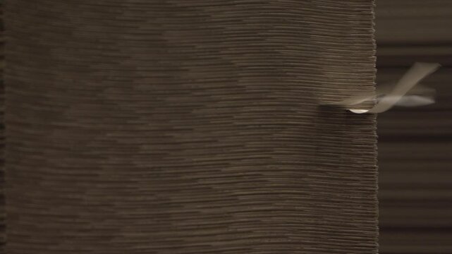 Wind flatters labels on cardboard stack in warehouse of finished products. Special building stores materials for further transportation to pick-up points