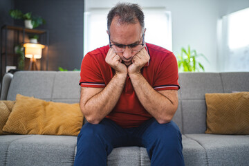 Man sitting alone at home looking sad and distraught