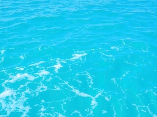 Fototapeta premium Pure blue turquoise water with foam from waves creating a textured ocean surface, tranquil, sea, peaceful