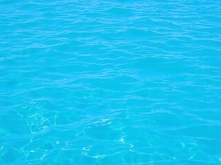 Fototapeta premium Pure blue turquoise water with foam from waves creating a textured ocean surface, wave, tropical