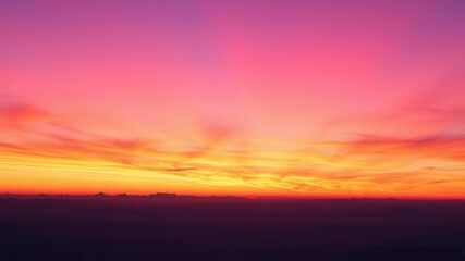 Vibrant hues of pink, orange, and purple streak across the sky as the sun sets, creating a mesmerizing abstract display, gradient, purple