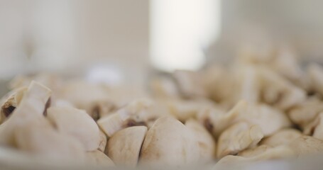 Pouring sliced mushrooms into a bowl