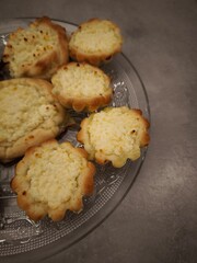 Delicious homemade mini cheesecakes resting on glass plate, baking concept copy space