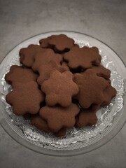 Chocolate flower shaped cookies piled on glass plate christmas time copy space