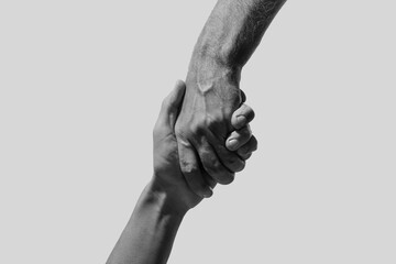 Help and support. People holding hands on light grey background, closeup. Toned in black and white