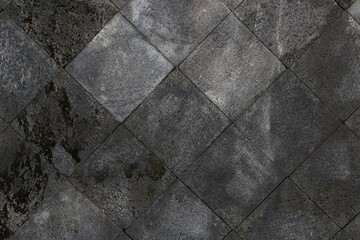 The texture of the gray cement wall forms a square pattern.