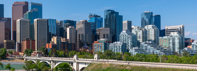 Panoramic city skyline in Calgary, Alberta during summer time with beautiful blue sky day Centre St Bridge in view.