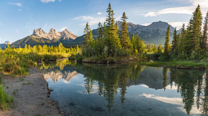 Three Sisters in Canmore seen at golden hour, sunset on blue sky day, afternoon with calm, peaceful...