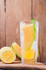 Melon juice, lemonade in a glass with ice and melon slices decorated with mint leaves. Fresh summer drink concept. Ramadan -kareem.
