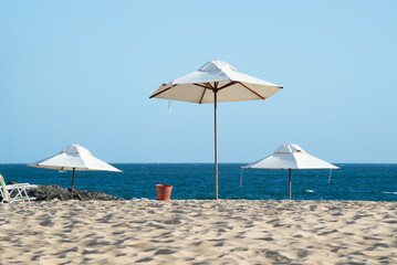 Umbrellas on the beach with blue sky and sea in the background. Vacation concept.