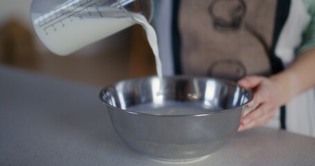 Woman Pouring Milk Into Metal Bowl and Making Dough