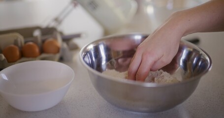 Close-up of chef's hand moving flour with hand preparing dough