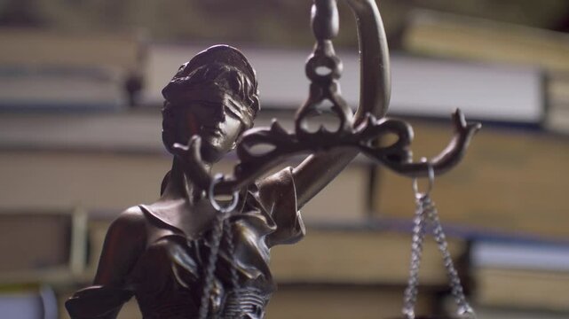 Statue of Themis or Lady Justice on bookshelf background. Law Firm or Business Concept. International Court of Justice
