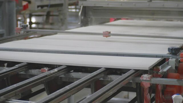 In a ceramic tile factory, conveyor belt systems facilitate the flow of production. The raw materials are transformed into finished tiles with precision and efficiency
