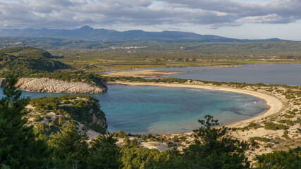 Idyllic voidokilia beach with turquoise colored water and Gialova Lagoon from high point of view on a sunny spring day, Messinia, Peloponnese, Greece