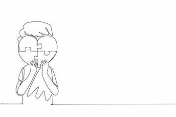 Single continuous line drawing boy holding a heart shaped 4 piece puzzle. Symbolic. Non verbal expression. Needs excessive affection. World Autism Awareness Day. One line design vector illustration