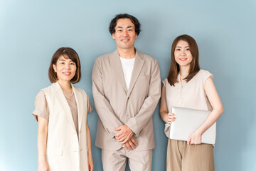 オフィスでノートパソコンを持って立つ男女のビジネスマン
