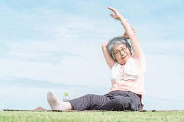 公園で運動・体操・ヨガをするシニア・高齢者女性
