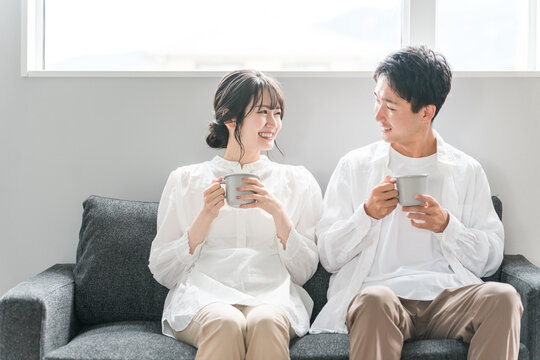 家のリビングのソファでくつろぐ夫婦・カップル・パートナー・家族
