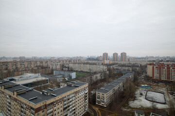 Obraz premium Urban Landscape Featuring Overcast Sky Alongside Various Residential Buildings and Structures