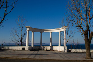 An architectural structure with columns - a colonnade. Decorative structure against the backdrop of the sea