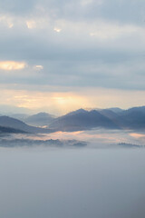 Fototapeta premium Aerial view morning scenery Mist flowing over the high mountains The movement of fog and clouds, 