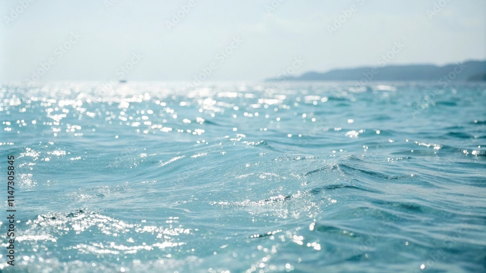 Poster sunlit ripples on the surface of a calm, turquoise ocean, creating a serene and sparkling scene.