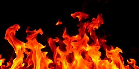 Fototapeta premium Dynamic fire flames soaring against a dark black background, motion, blazing