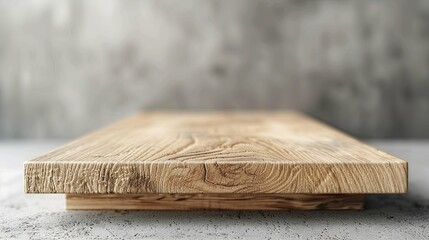 Rustic light brown wooden plank on a concrete surface, blurred background.