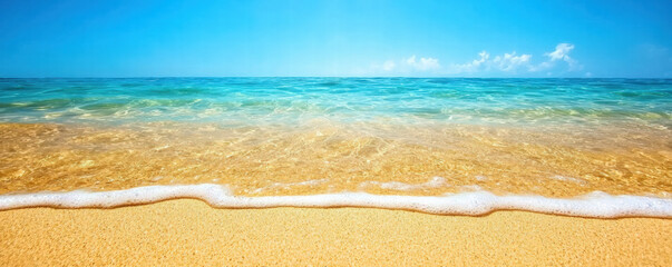 Obraz premium A tranquil beach scene featuring golden sand and clear blue water under a bright sky, evoking a sense of relaxation and natural beauty.