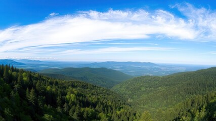 Naklejka premium Majestic mountain range with stunning panoramic view of lush green forests and clear blue sky, nature, panoramic view, blue sky