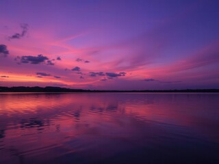 Naklejka premium A stunning sunset over a serene lake, with vibrant colors painting the sky and reflecting on the water below, reflection, dusk, peaceful