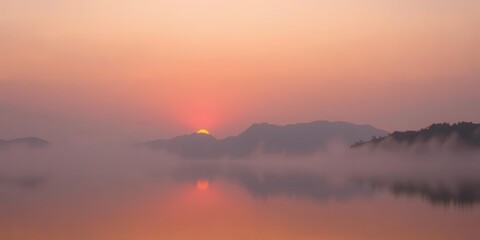 Fototapeta premium Sunset over misty mountains with orange and pink hues reflecting on calm lake, orange, nature, calm