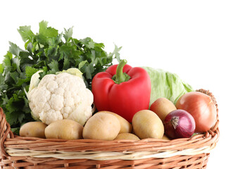 Different ripe vegetables in wicker basket isolated on white