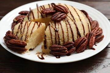 Delicious sweet semolina halva with pecans on wooden table, closeup