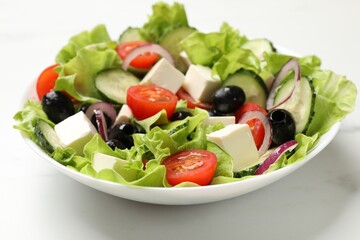 Delicious fresh Greek salad on white table, closeup