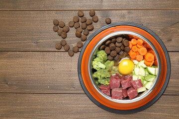 Dry pet food and natural products on wooden table, top view. Space for text