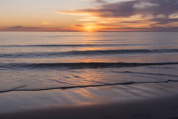 Peaceful sunset over the ocean with gentle waves and colorful sky.