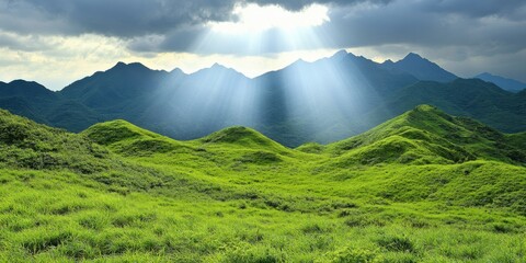 Fototapeta premium Breathtaking Sunlight Breaking Through Clouds Over Rolling Green Hills Mountainous Landscape Nature Serene Environment Wide-Angle View Tranquil Concept for Nature Lovers