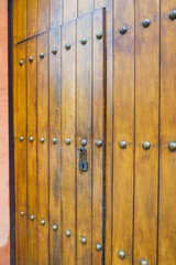 Fototapeta premium Close up of old Key in wooden door at home, Brown Wood Front Door with Ornate Brass Skeleton Key,copy space..