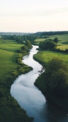 Serene river flowing through lush green fields and rolling hills.