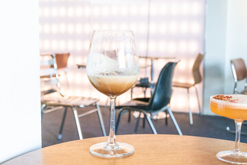 Glass of Cold Mocktail on table,female hand swirling red wine in wine glass,Friends cheering with wineglasses,eating and holidays concept..