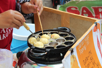 Street vendor cooking and selling takoyaki, Japanese food