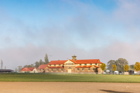 Historic Armidale Showground Pavilion on foggy autumn morning with arena in foreground
