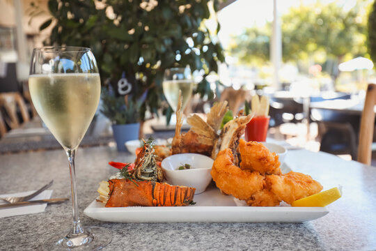 Seafood platter in alfresco dining setting featuring squid, prawns and barramundi wings