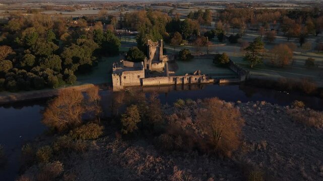 Desmond Castle Adare On The Bank Of River Maigue On Frosty Morning In Ireland. - aerial forward shot