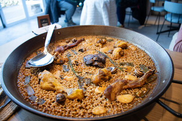 Spanish Valencian paella of traditional rice with chicken lamb escargot with serving spoon