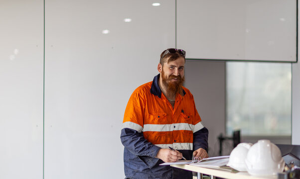 Male worker writing on the paper on the desk in the office.