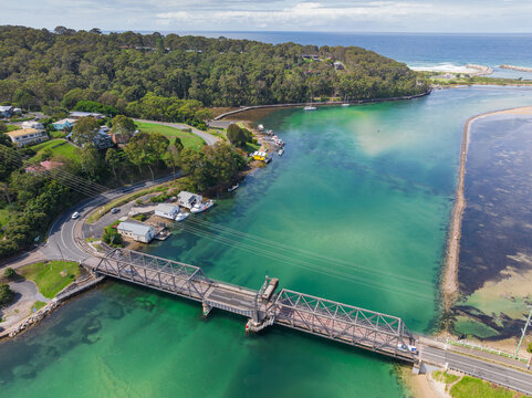 Aerial view of a steel truss bridge of a torquoise coastal inlet