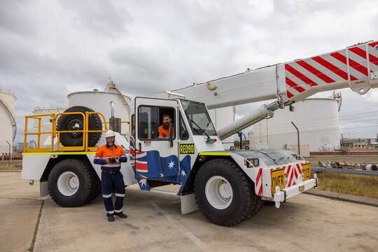 Male workman standing beside a pick and carry crane